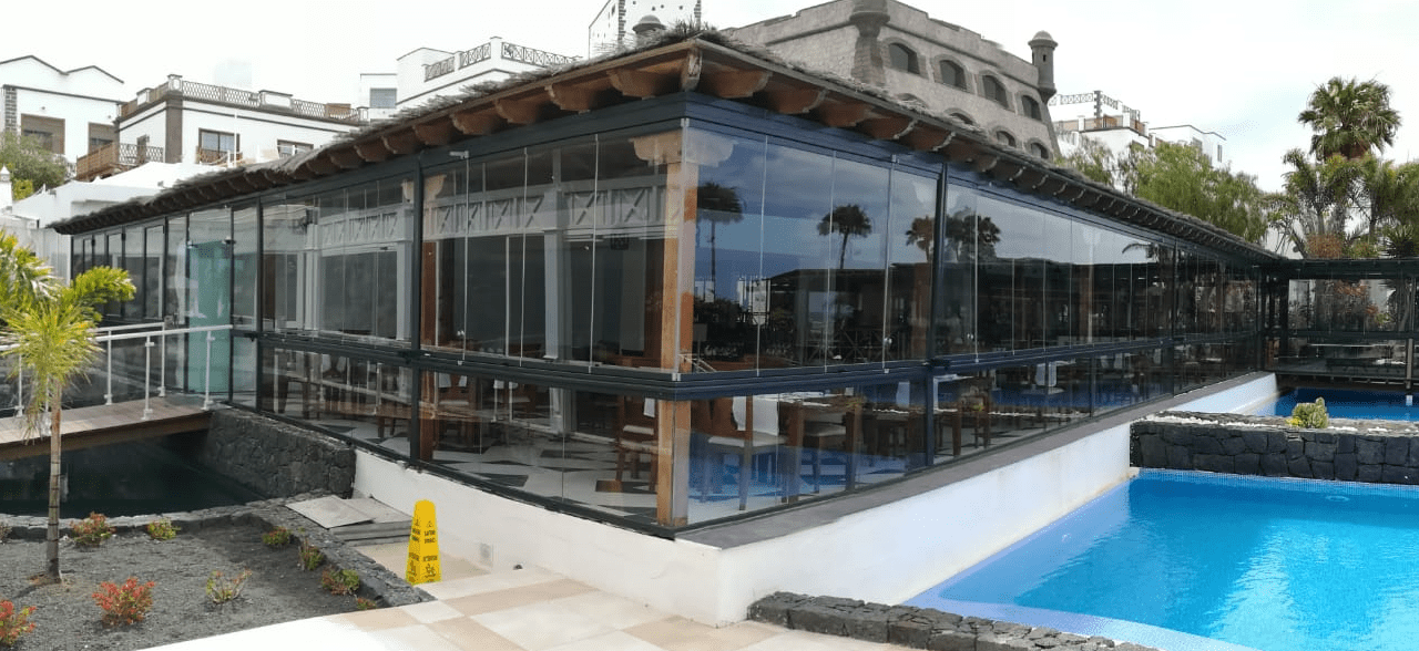 Un gran edificio con una piscina delante.