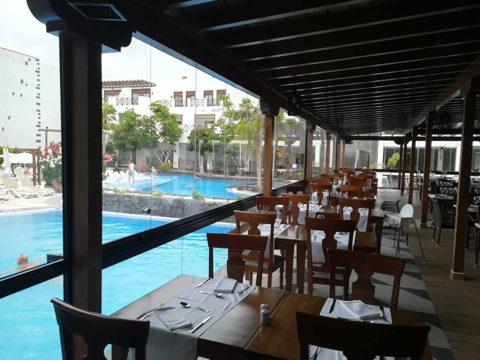 Un restaurante con mesas y sillas con vistas a una piscina.