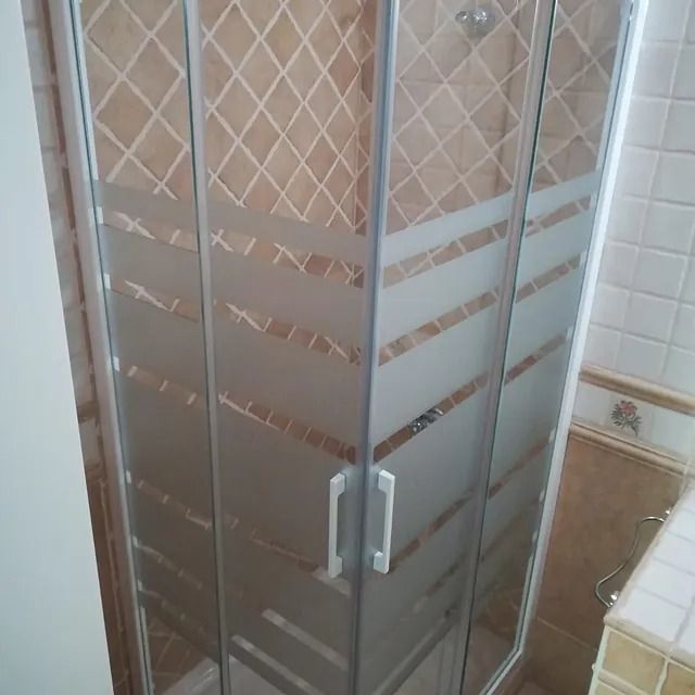 Un baño con cabina de ducha con puerta corrediza de cristal.