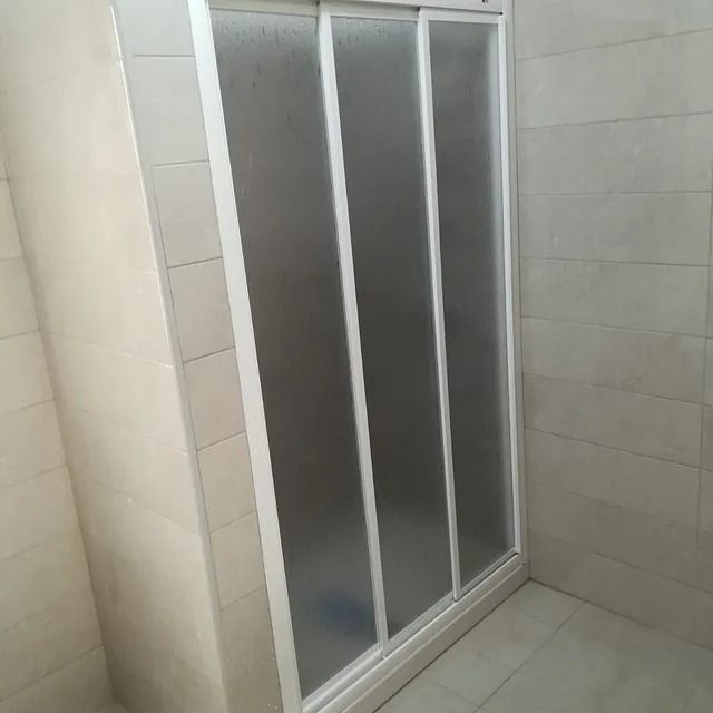 Hay una puerta de ducha corrediza de vidrio en el baño.