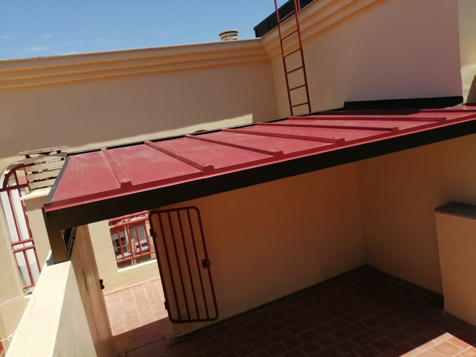 Una habitación vacía con un techo rojo y una escalera.