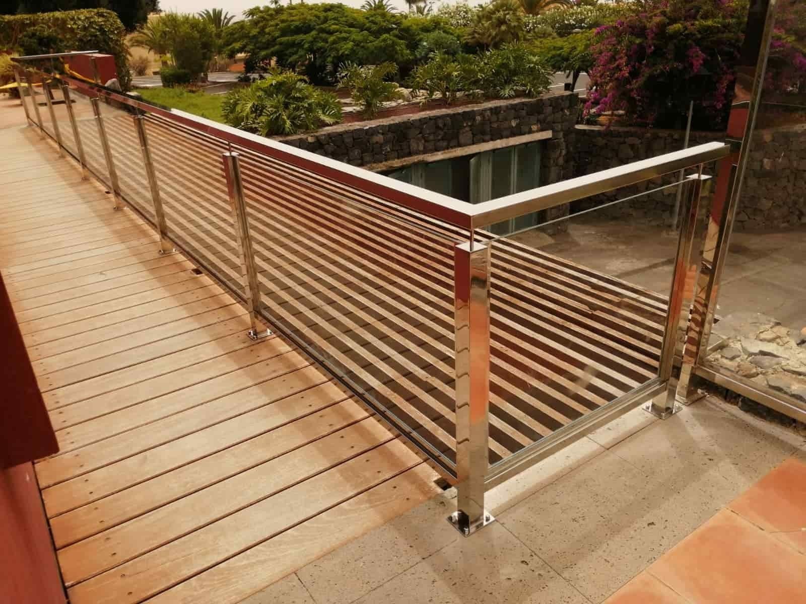 Una terraza de madera con barandilla de acero inoxidable