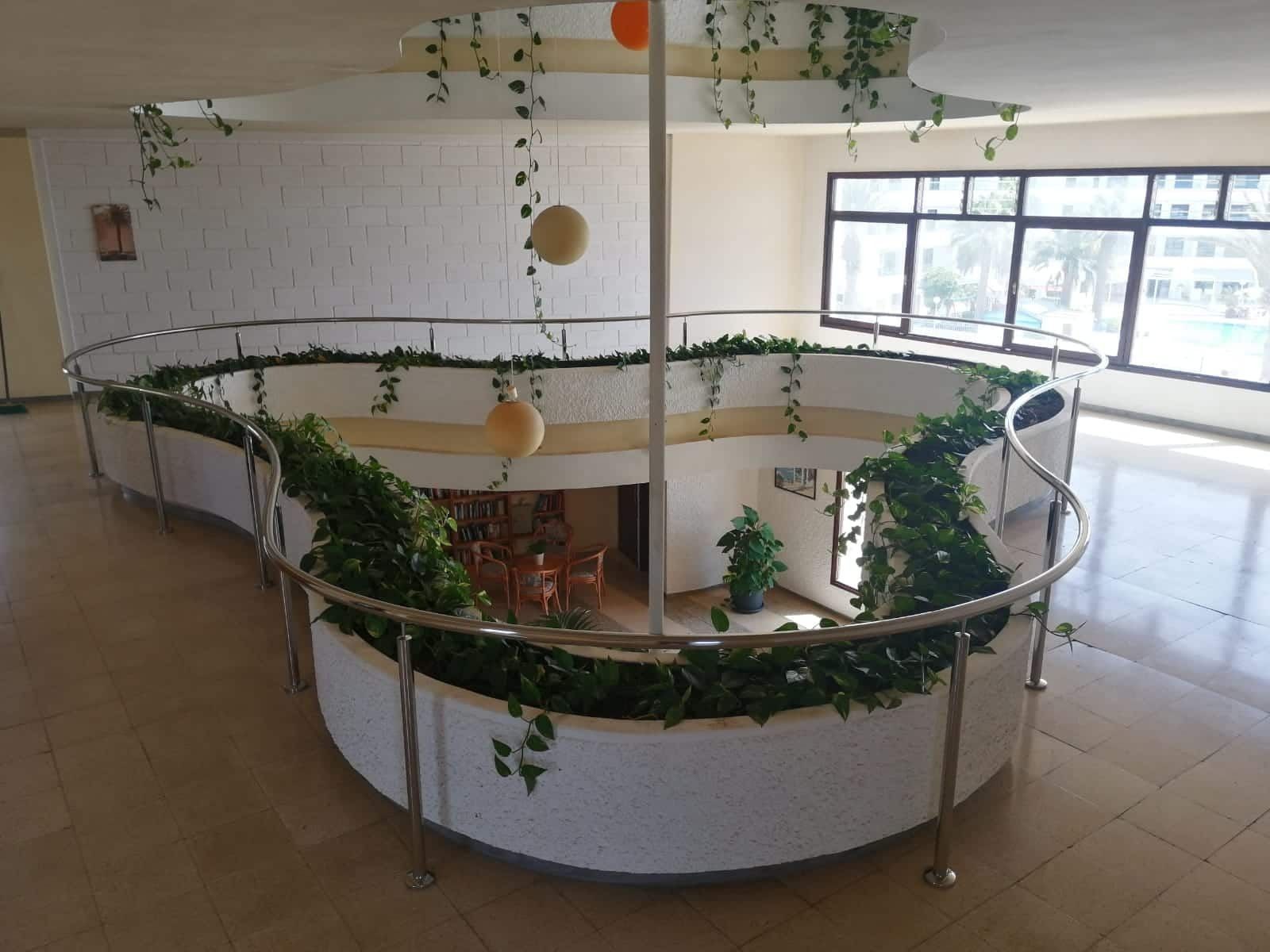 Una habitación con una jardinera circular en el medio.