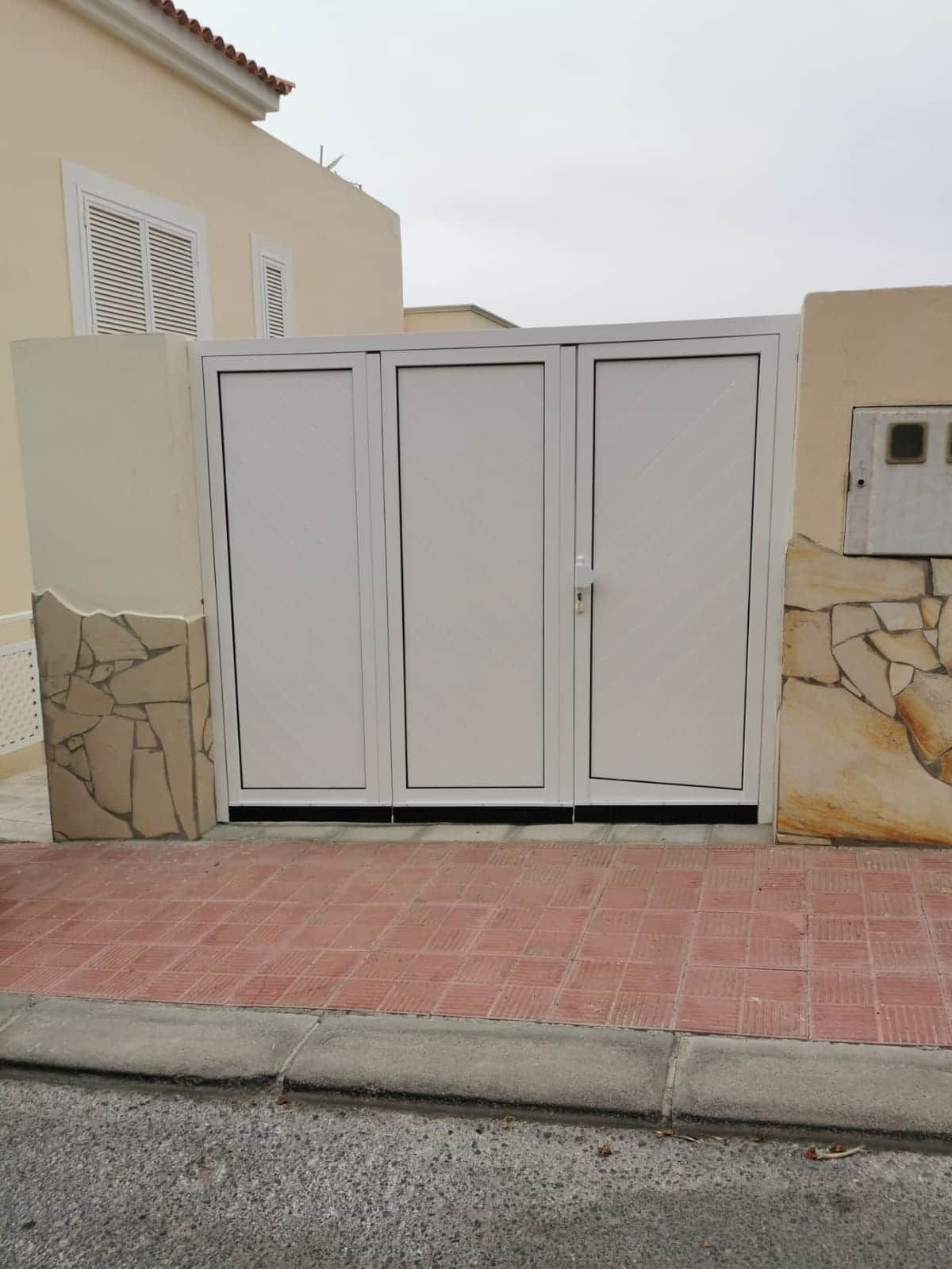 Una puerta blanca está situada frente a una casa.