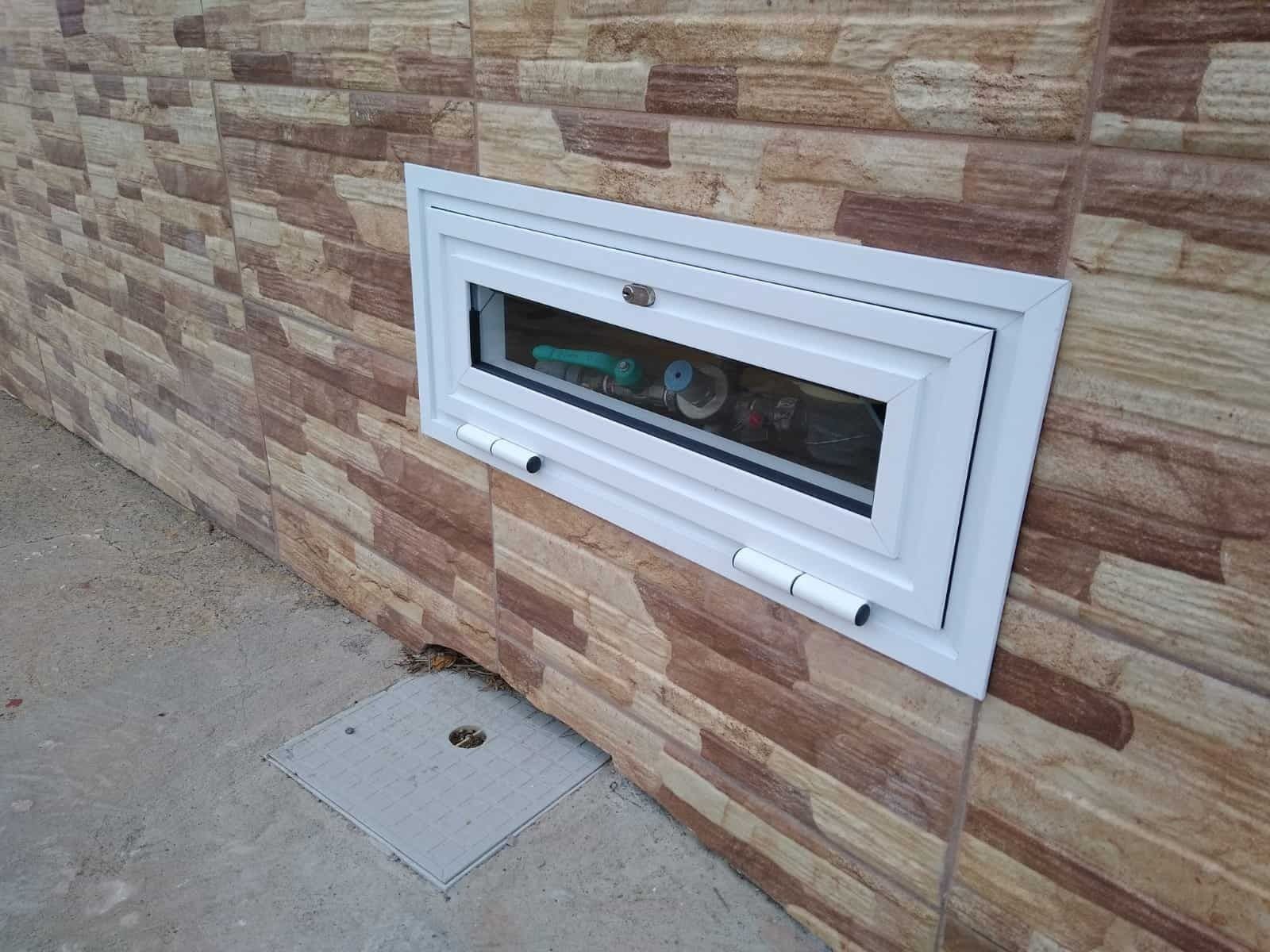Una ventana blanca está construida en una pared de ladrillos.