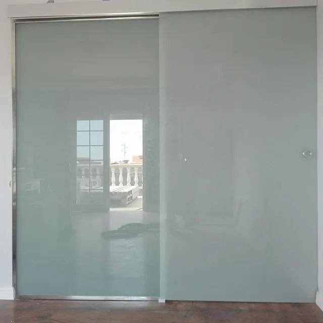 Una puerta corrediza de vidrio en una habitación con un balcón al fondo.