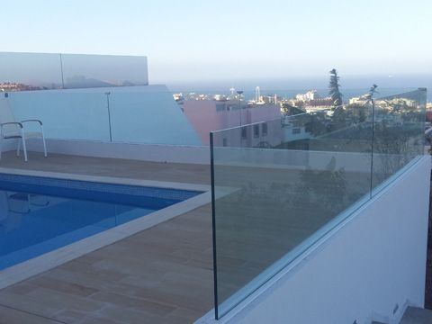 Una piscina con una valla de cristal a su alrededor.