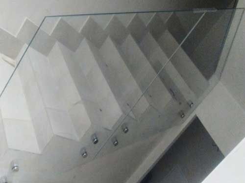 Un primer plano de una barandilla de vidrio en una escalera.