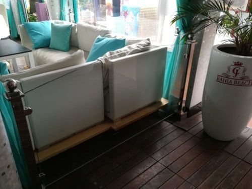 Un sofá blanco con almohadas azules está junto a una planta blanca en maceta.