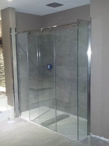 Una cabina de ducha con puertas corredizas de vidrio en un baño.