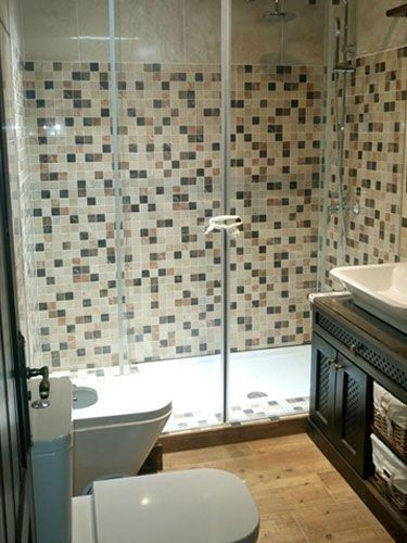 Un baño con inodoro, lavabo y ducha.