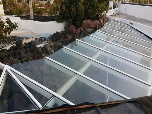 Un techo de cristal transparente con un marco blanco