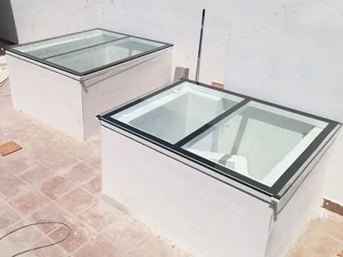 Dos cajas blancas con tapas de vidrio están colocadas una al lado de la otra sobre un piso de baldosas.