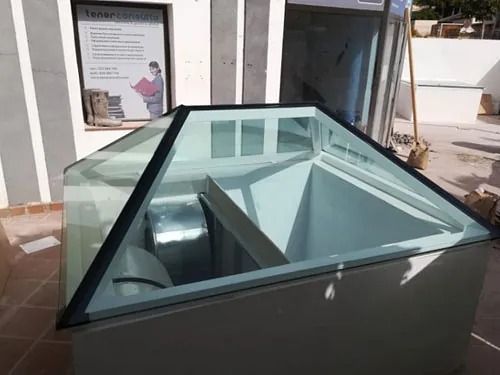 Una pirámide de cristal con una escalera que conduce a ella.