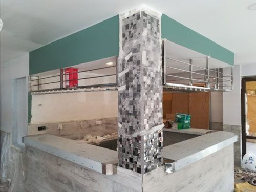 Un rincón de una cocina con un pilar en el medio.