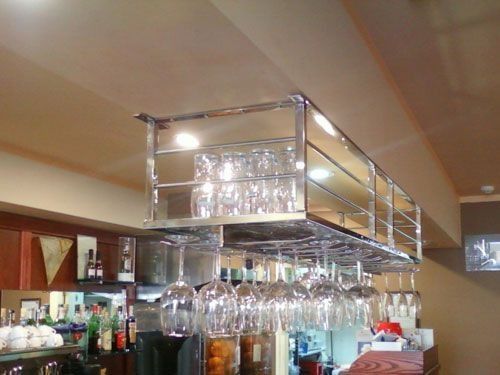 Un bar con copas de vino colgando del techo.