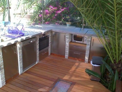 Una cocina con electrodomésticos de acero inoxidable y suelo de madera.