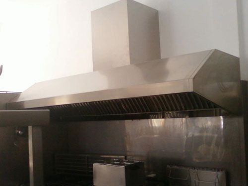 Una cocina con una campana de acero inoxidable encima de la estufa.