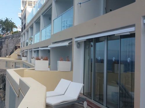 Un gran edificio con balcón y puertas corredizas de vidrio.