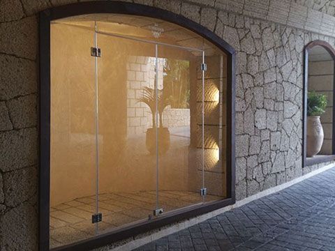 Una habitación vacía con una puerta de cristal y una pared de piedra.