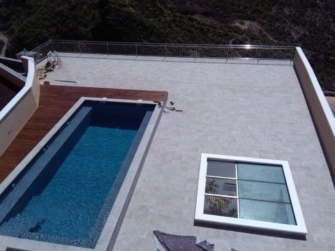 Una gran piscina está en el tejado de una casa.
