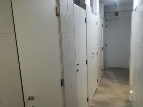 Un pasillo largo con puertas blancas en un baño.