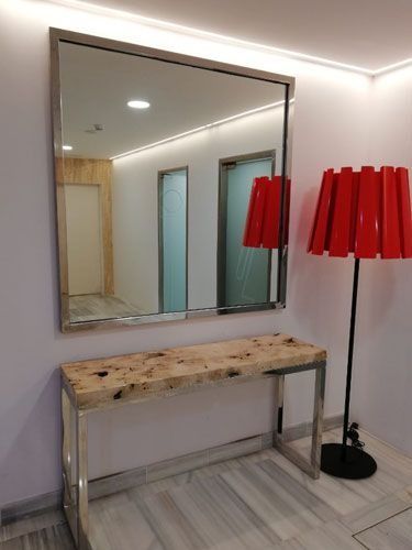 Una habitación con una mesa, un espejo y una lámpara