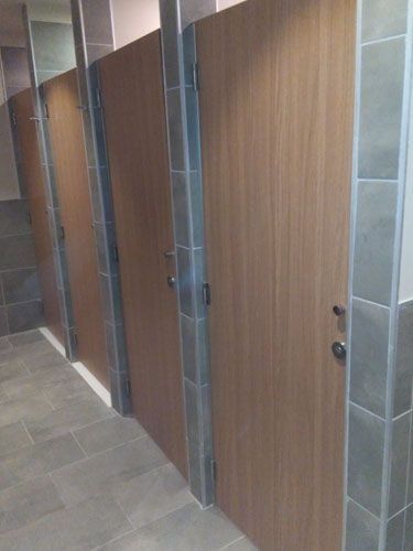 Una fila de puertas de madera en un baño público.