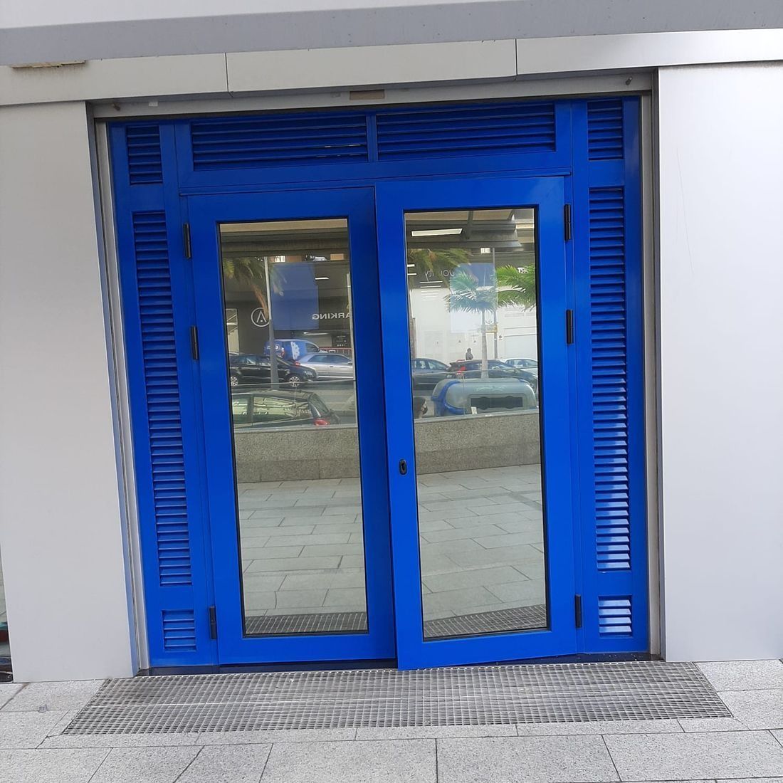 Una puerta azul con persianas a los lados.