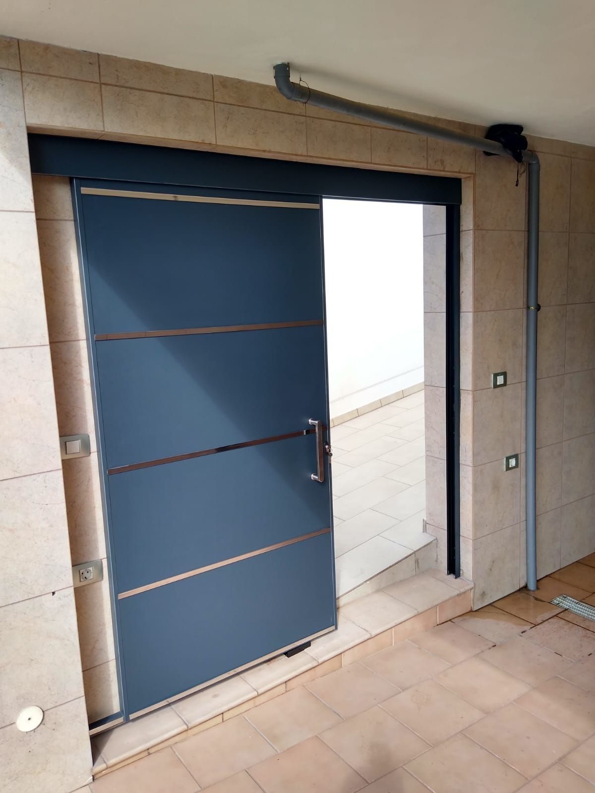 Una puerta corrediza azul está abierta en un edificio.