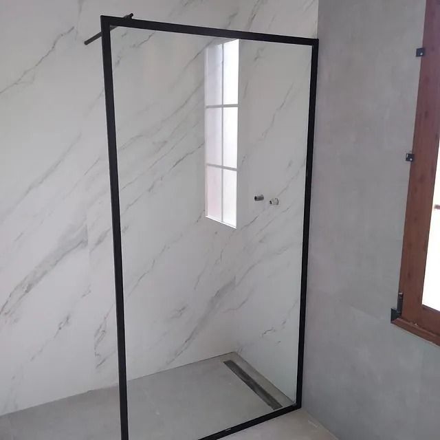 Un baño con ducha a ras de suelo y ventana.