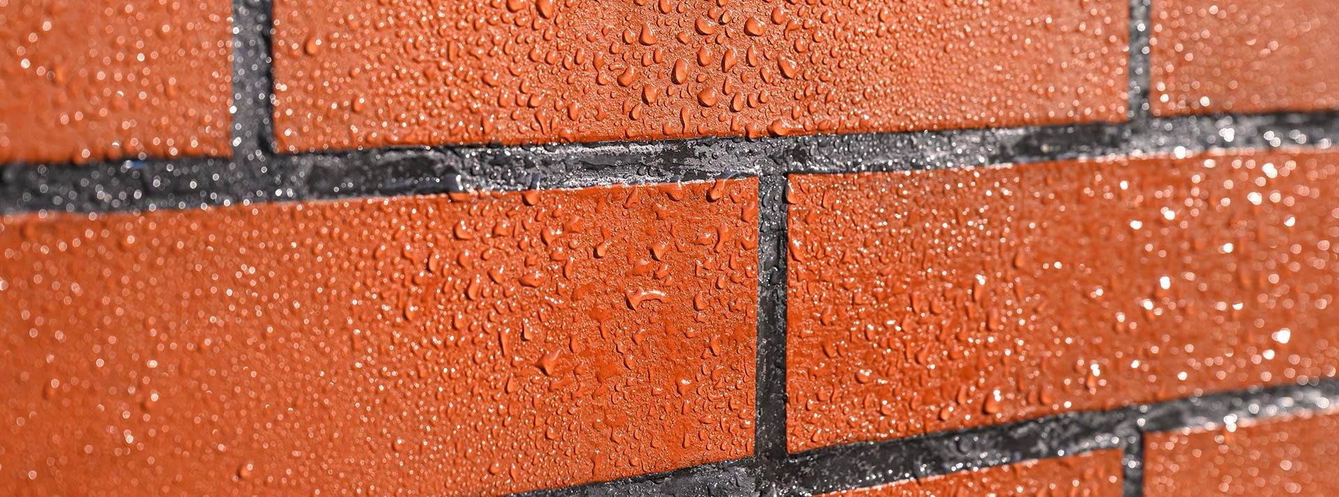 Mur en briques avec des gouttes d'eau dessus