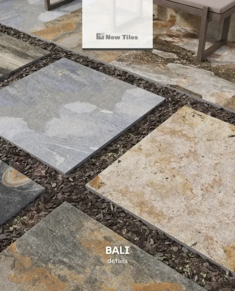 Pavimento de baldosas cuadradas, de diferentes colores, separadas por pequeñas piedras marrones, en el exterior.