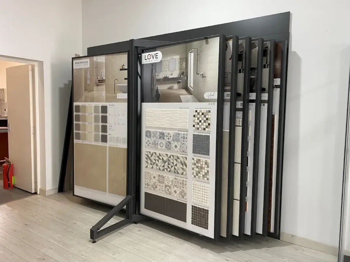 Estante de exhibición de azulejos con varias muestras de azulejos en un entorno de sala de exposición.