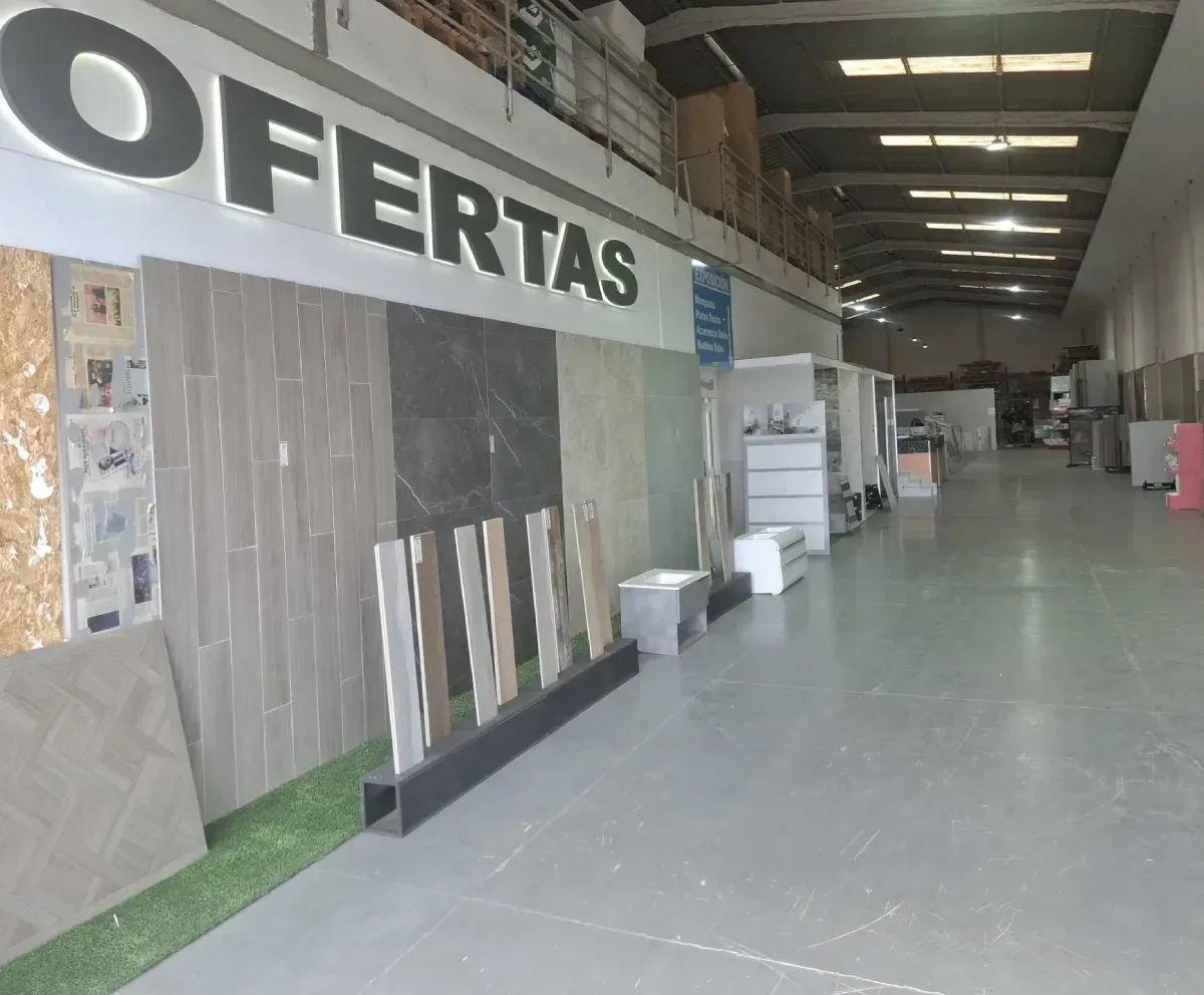 Interior de una tienda que vende muestras de azulejos, con un cartel de