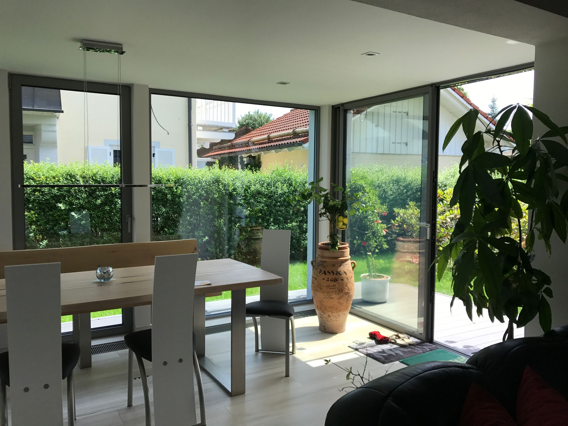 Moderner Wintergarten mit Essbereich und vielen Pflanzen.