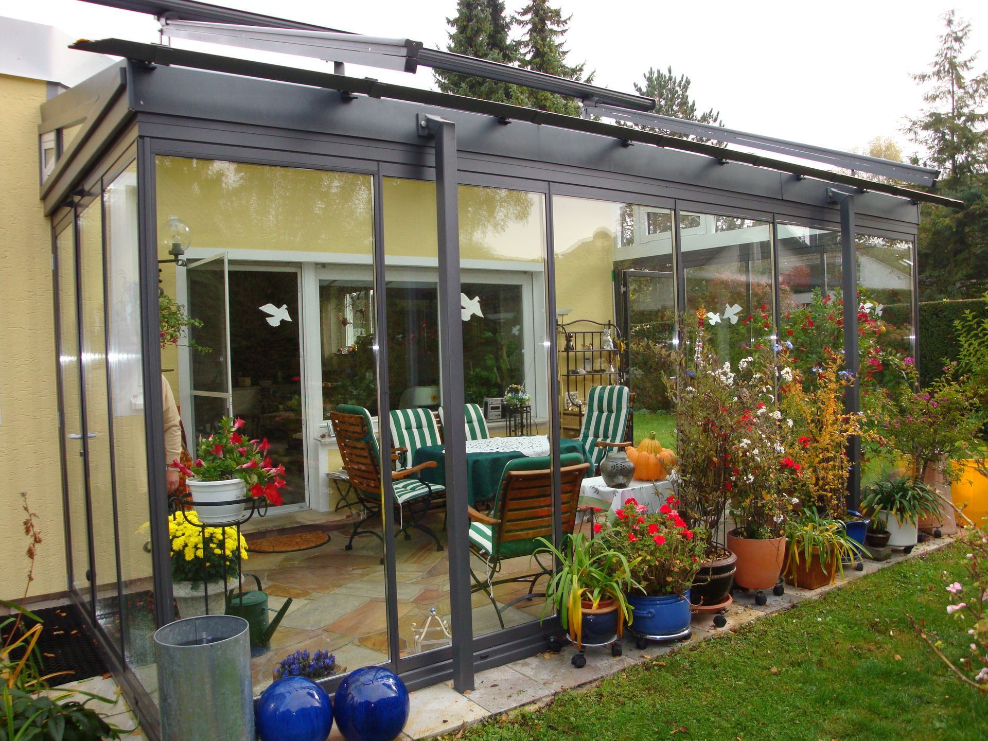 Wintergarten mit Pflanzen und Sitzbereich im Garten.