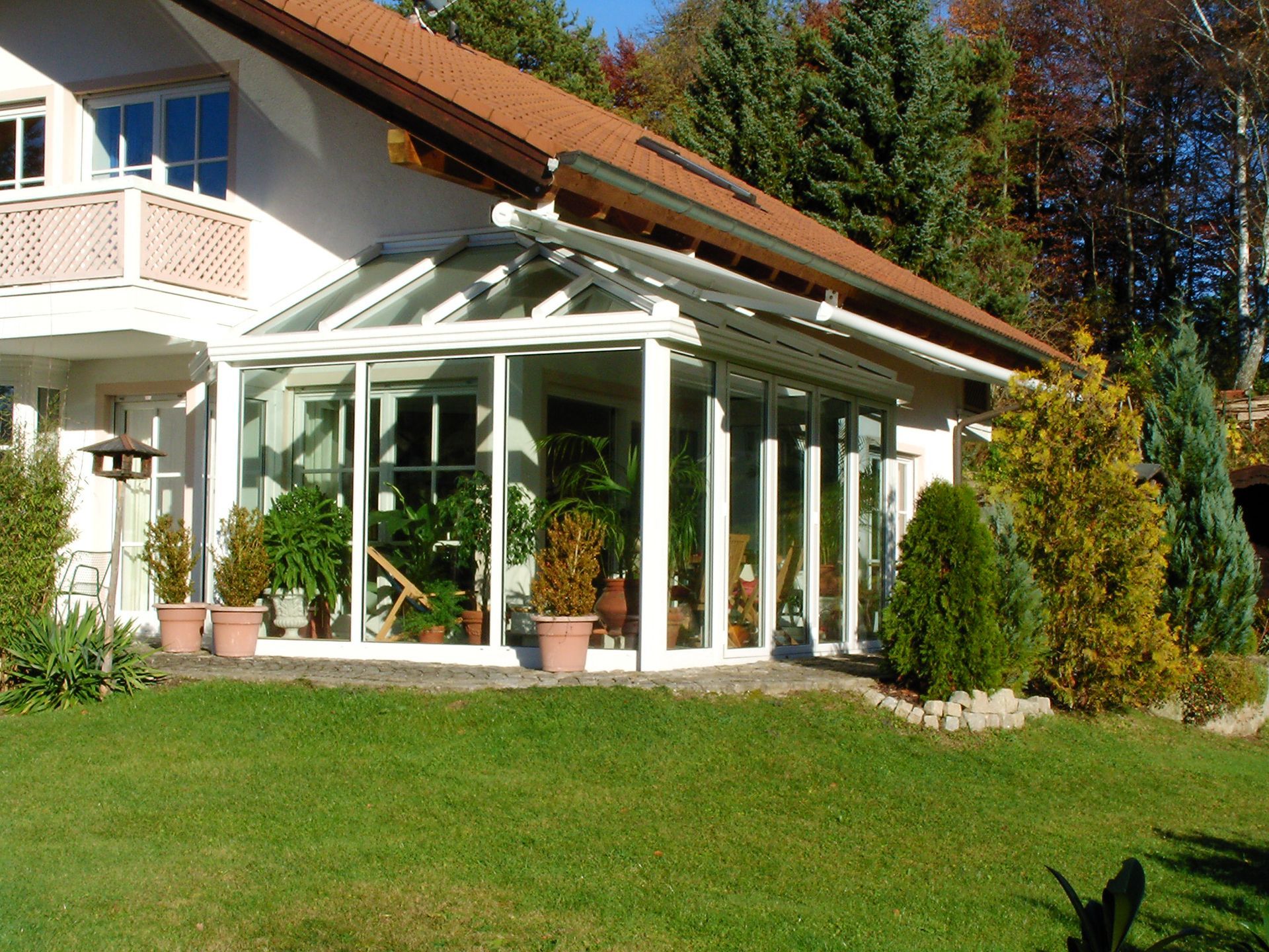 Wintergarten mit weißer Konstruktion an einem Wohnhaus.