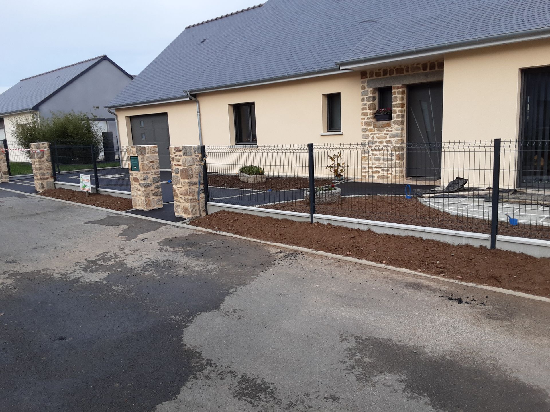 Des pièces métalliques peintes en blanc sont suspendues à des crochets à l'intérieur d'une cabine de peinture.