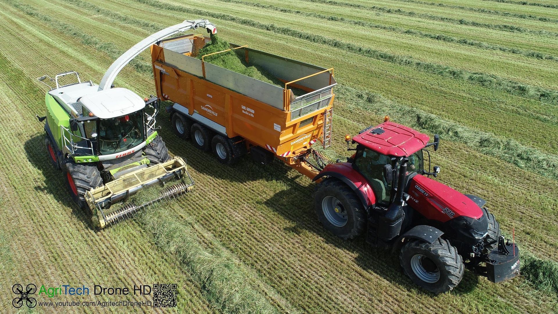 Des pièces métalliques peintes en blanc sont suspendues à des crochets à l'intérieur d'une cabine de peinture.