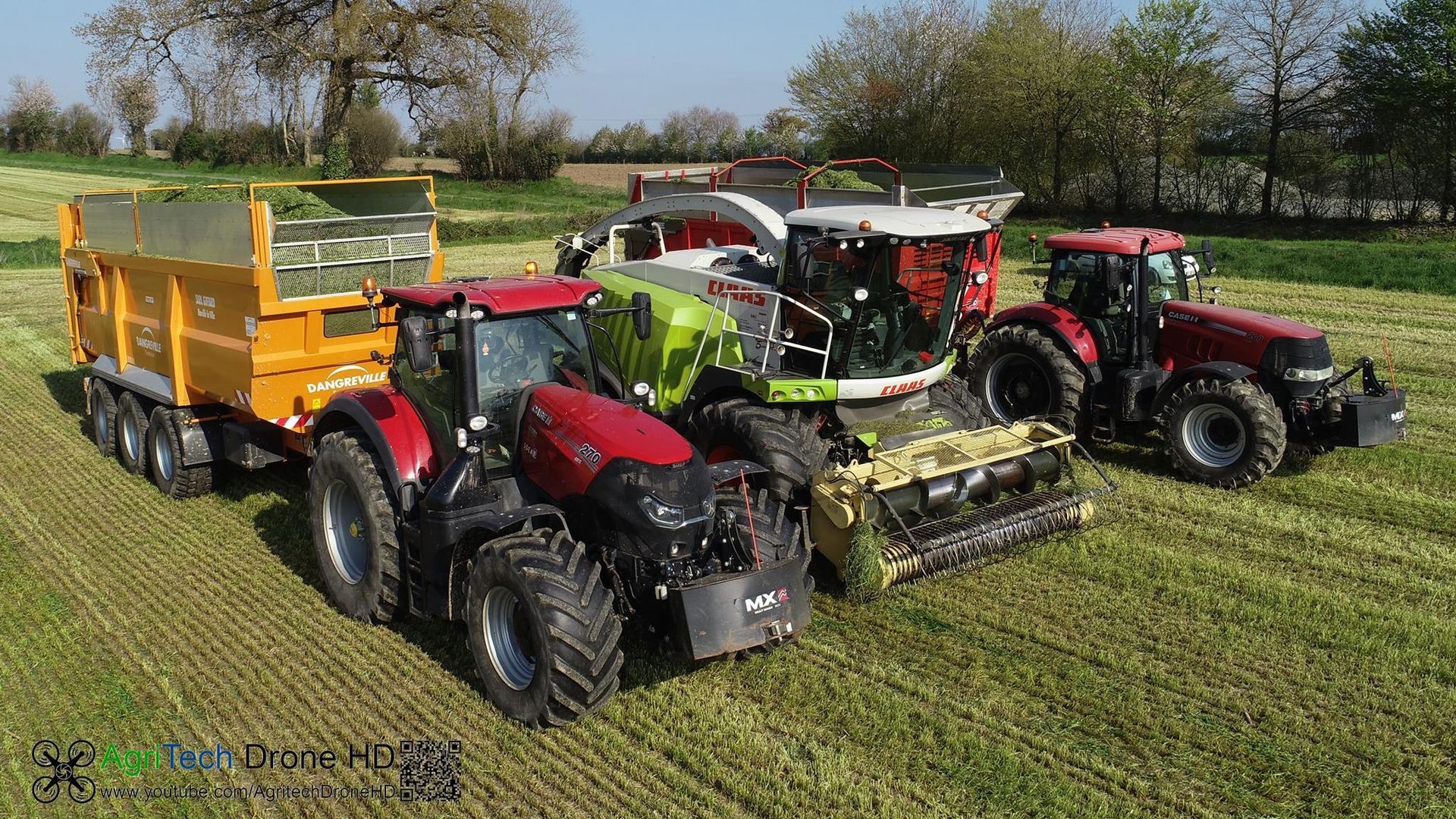 Des pièces métalliques peintes en blanc sont suspendues à des crochets à l'intérieur d'une cabine de peinture.