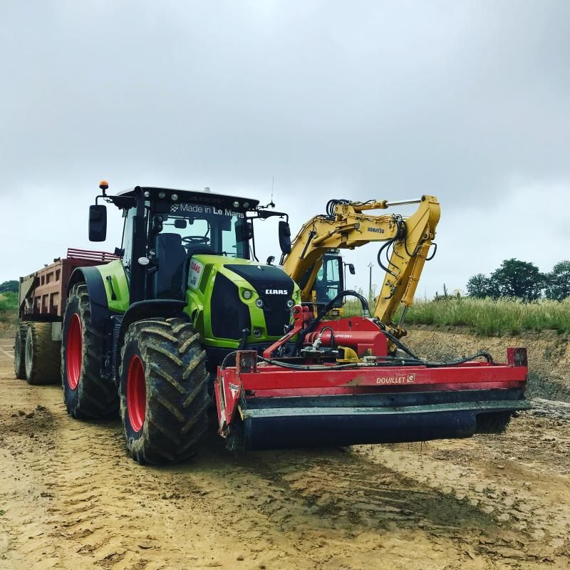 Tracteur vert avec une tondeuse rouge et une remorque 