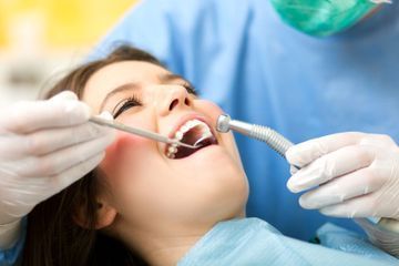 Una mujer está siendo examinada por un dentista.