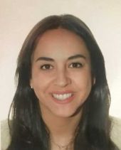 Una mujer con cabello largo y oscuro sonríe para la cámara.