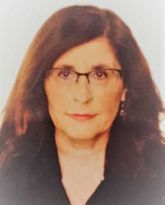 Un primer plano de una mujer que lleva gafas y pendientes.
