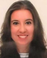 Una mujer con cabello largo y oscuro sonríe para la cámara.