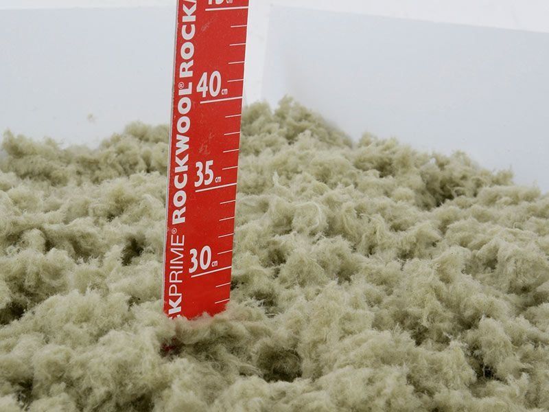 Montón de aislamiento de color claro con una regla roja, que muestra medidas entre 30 y 45.