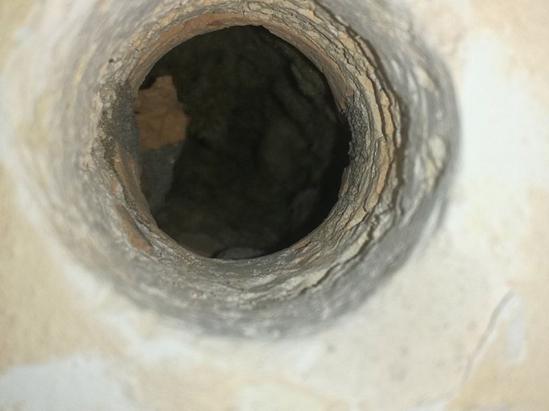 Mirando hacia abajo, a un pozo oscuro y redondo, hecho de piedra clara y desmoronada.