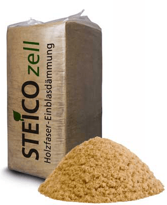 Saco de aislamiento de fibra de madera junto a una pila del mismo material, de color tostado.