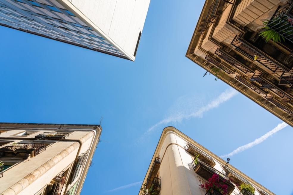 Vista de ángulo bajo de edificios contra un cielo azul brillante.